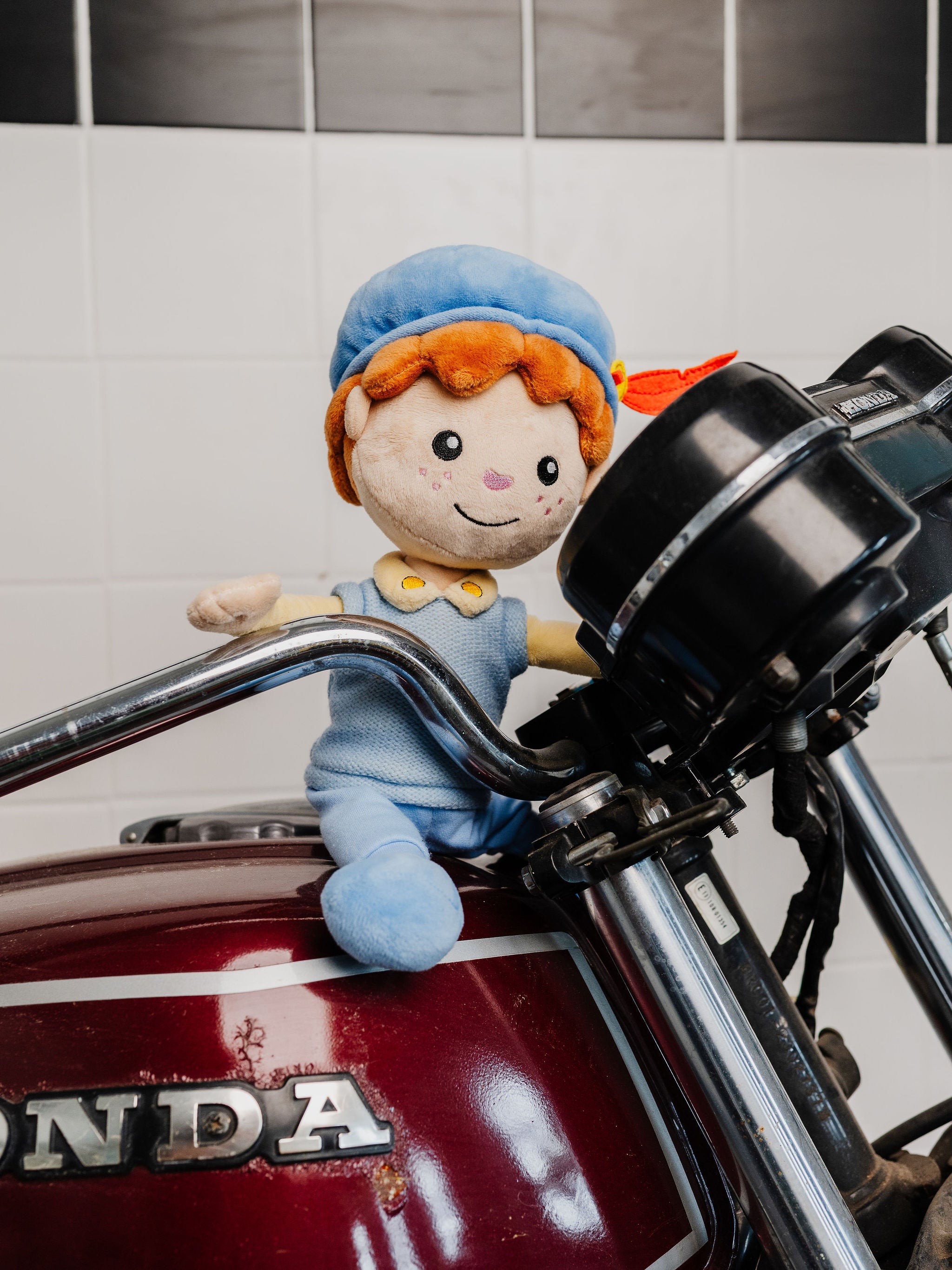 Piet die 't Ziet-knuffel op het stuur van een motor